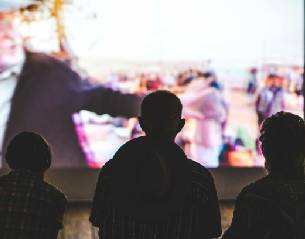 Des personnes regardant l'écran du festival. 